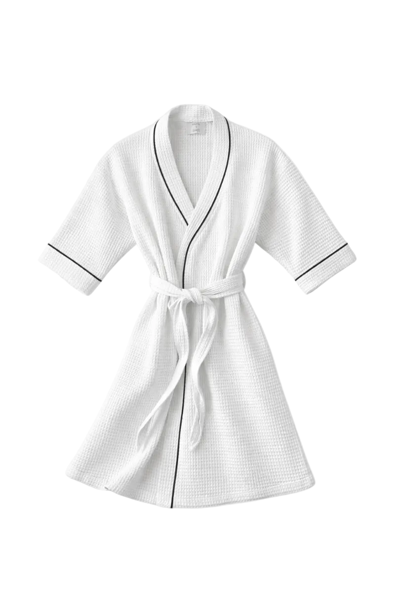 A white waffle-weave bathrobe with black piping trim and a matching tie belt, shown against a light gray background.